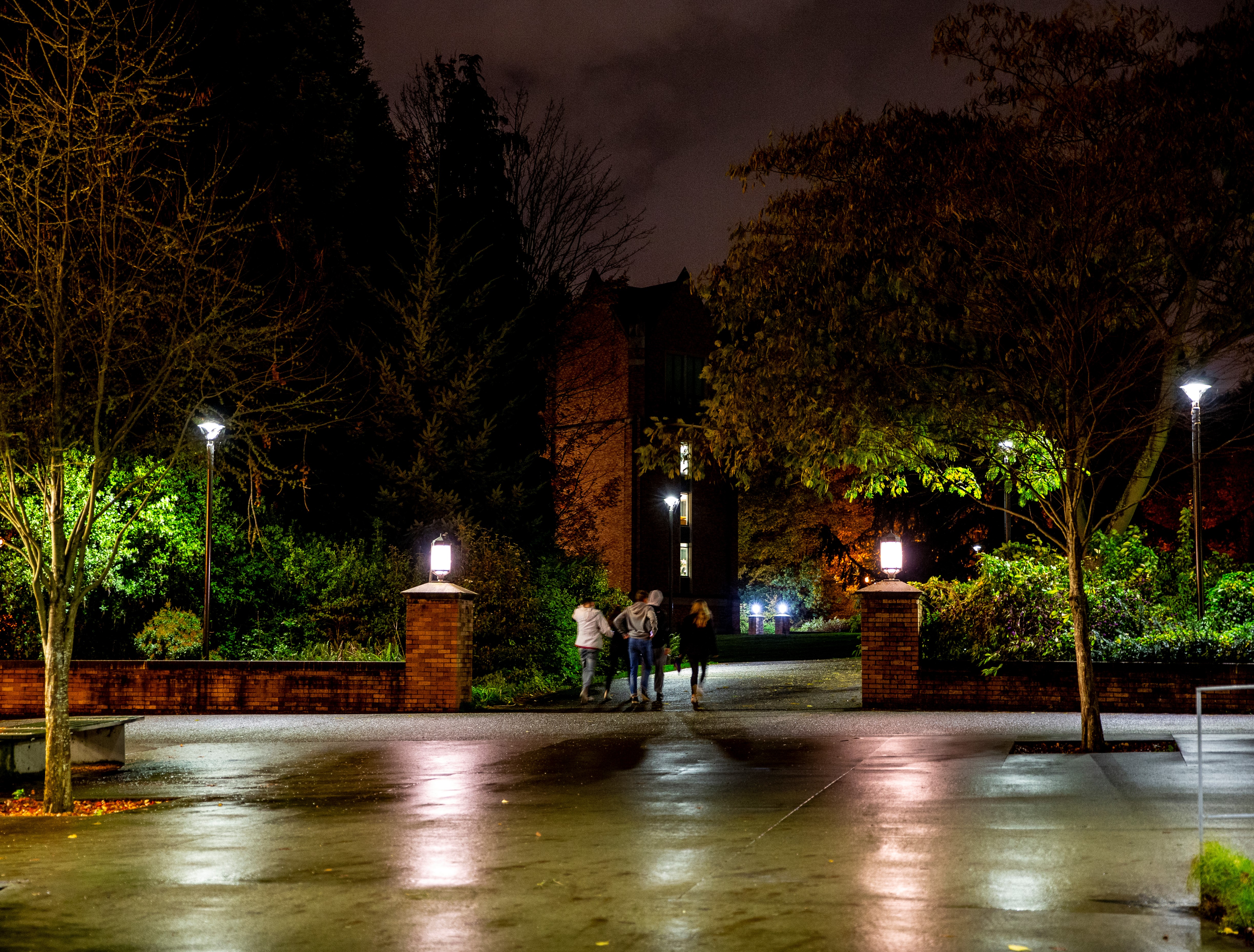 Students walking at night through campus.