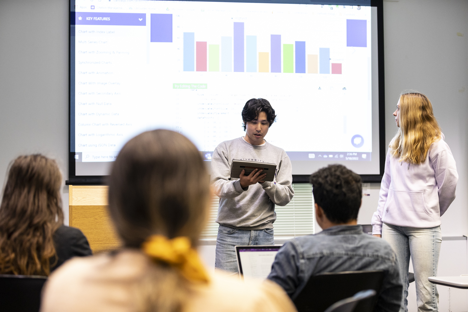 Students present data visualizations to an audience of peers