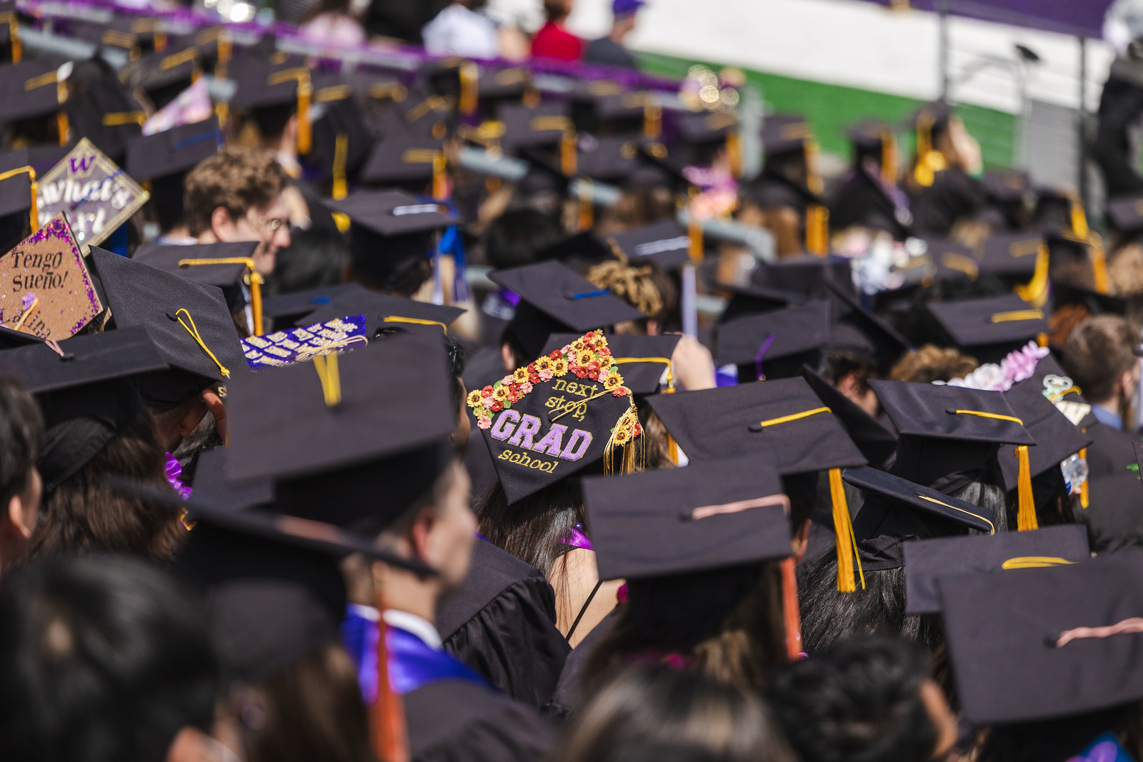 A graduating student wears a cap with "Next Stop, Grad School"